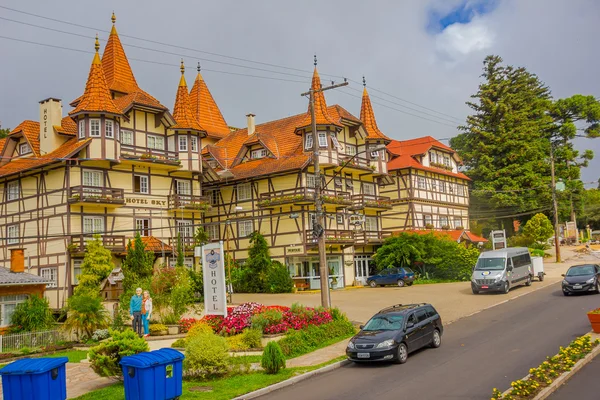 GRAMADO, BRAZIL - MAY 06, 2016: nice european style building with some trees in the entrance and cars parked outside