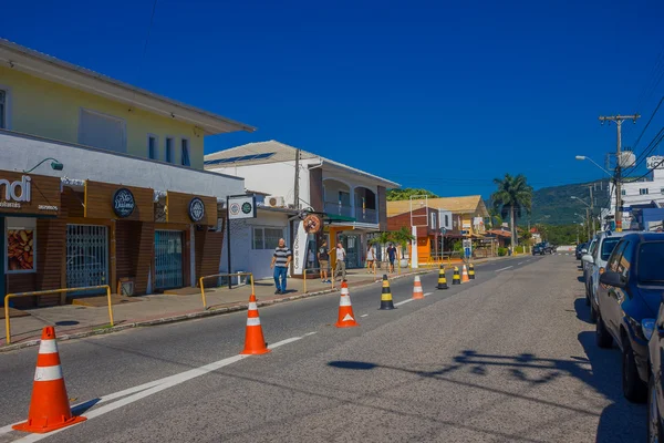 FLORIANOPOLIS, BRAZIL - MAY 08, 2016: nice little houses with stores in the lower level, cars parked in one side of the street, some cones placed in the middle of the street