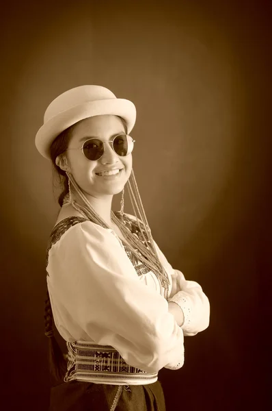 Beautiful hispanic model wearing light colored blouse, trendy sunglasses with matching hat, smiling posing for camera, studio background, black and white edition