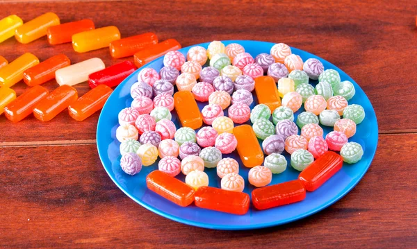 Variation of colorful hard candy lying on blue plate