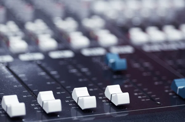 Closeup mixing faders and knobs as seen from above side angle, artistic studio equipment concept