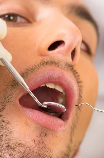 Closeup portrait of young handsome man at the dentist