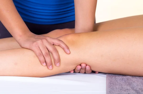 Woman lying while getting a leg massage concept of physiotherapy