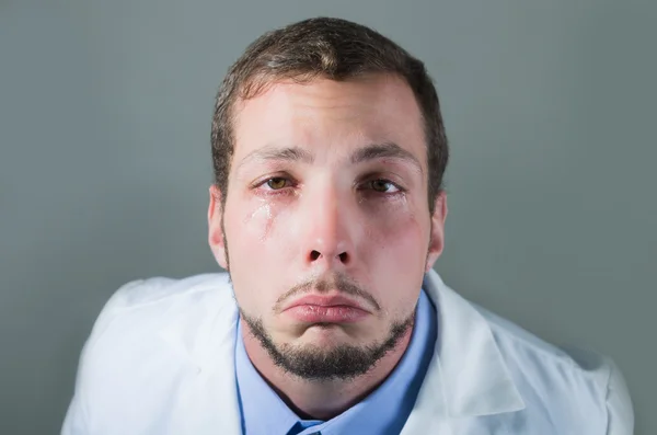 Closeup portrait of sad young doctor crying