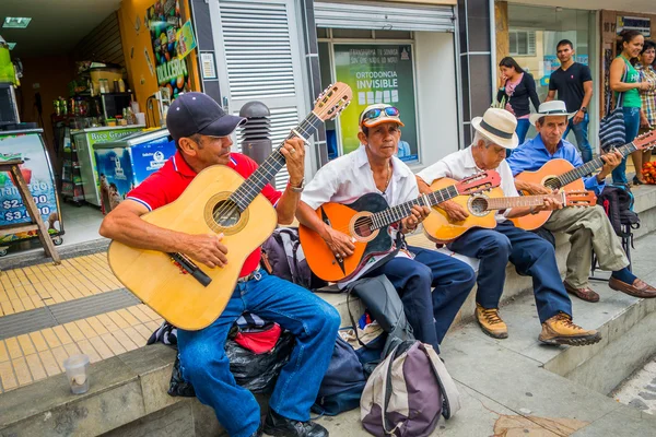Unidentify indigenous men playing guitar in the commercial street plaza of Armenia, Colombia
