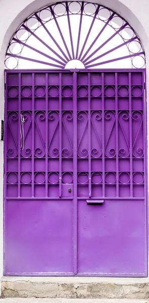 Purple colored door with metal bars