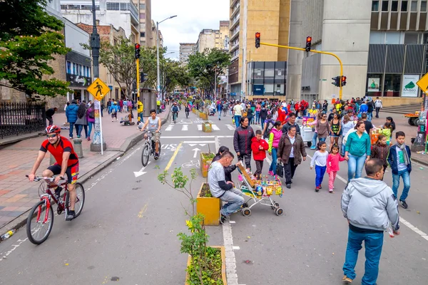 Unidentified hispanic pedestrians and cyclists moving through city street Candelaria area Bogota
