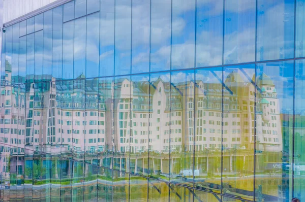 OSLO, NORWAY - 8 JULY, 2015: Reflection of beautiful typical european architecture pink office building on the waterfront, famous national newspaper Dagbladet has its offices here.