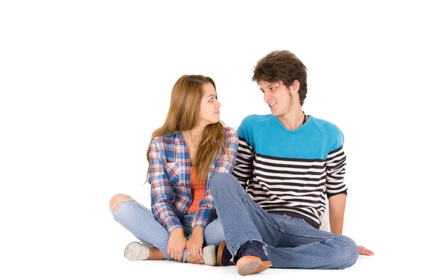 Portrait of attractive young happy couple in love man and woman isolated over white background sitting on floor looking to each other while dreaming
