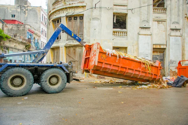 HAVANA, CUBA - DECEMBER 2, 2013: Waste collection vehicle picking up garbage container from the street