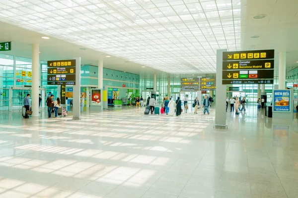 BARCELONA, SPAIN - 8 AUGUST, 2015: Inside arrivals terminal walking through building with signs and information around at airport