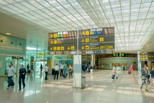 BARCELONA, SPAIN - 8 AUGUST, 2015: Inside arrivals terminal walking through building with signs and information around at airport