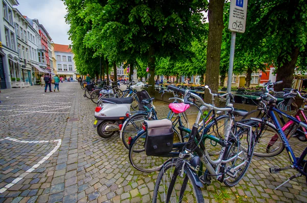 Bruges, Belgium - 11 August, 2015: Bike parking in city centre with bridge stoned road passing and green vegetation sorrounding