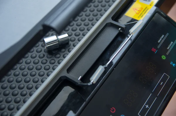 Print screen machine closeup with small metal tool bit lying on bubble plastic pattern surface