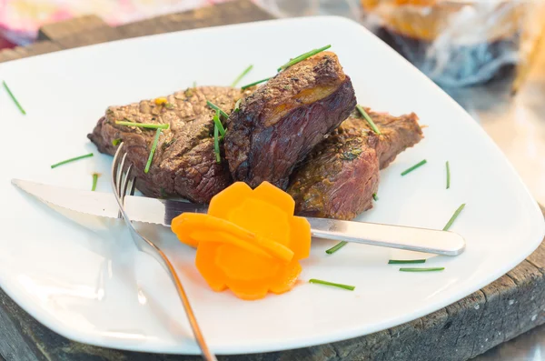 Delicious rump steak cooked to perfection and placed upon white dinner plate, elegant presentation