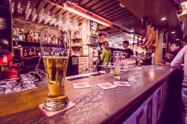 BRUSSELS, BELGIUM - 11 AUGUST, 2015: Glass beer sitting on bar counter inside Delirium Bar, selection of other beverages in background