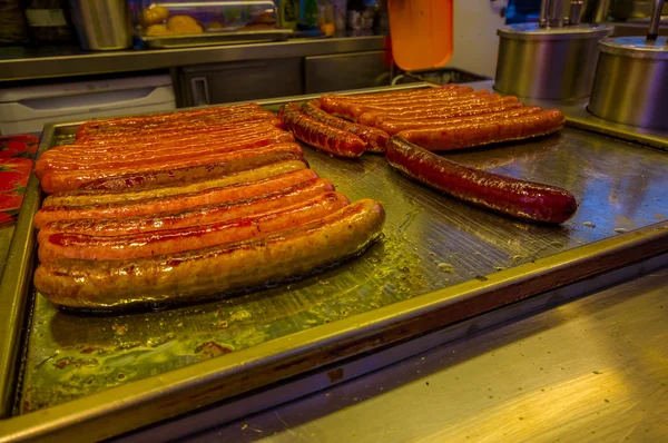 Vienna, Austria - 11 August, 2015: Closeup of classic Austrian bratwurst sausages lying on heated metal surface, display for customers