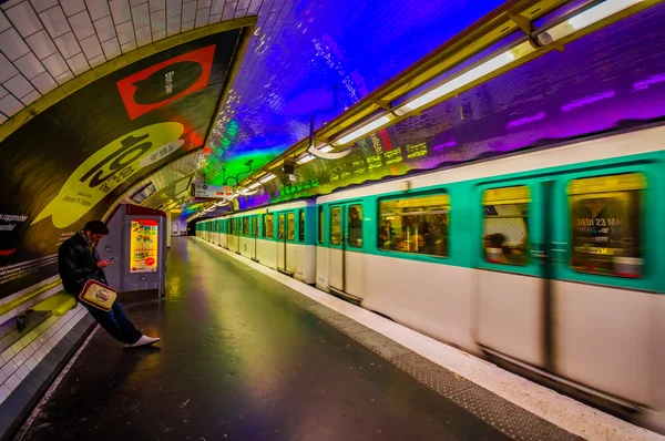Paris, France - June 1, 2015: Metropolitain subway metro station, train rapidly passing by platform with cool neon lights