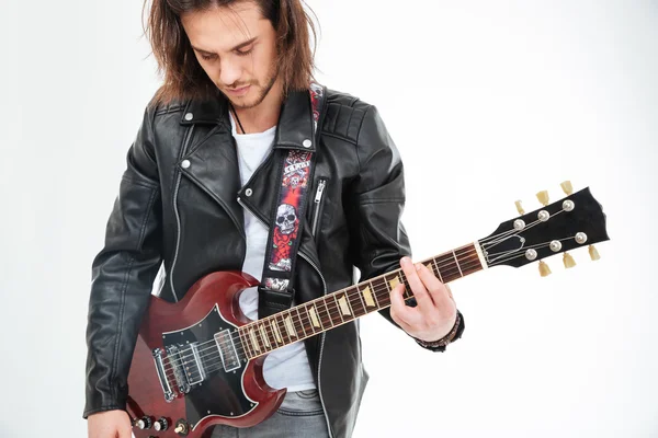 Handsome young man black leather jacket playing electric guitar