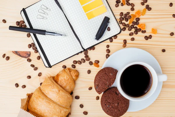 Sweet breakfast and notepad in a mess on the table