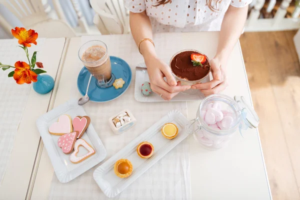 Top view of dessert, cakes, cookies and latte on table