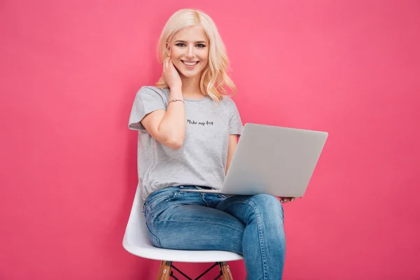 Young woman sitting on the chair with laptop