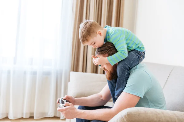 Man playing computer games while little son covering his eyes