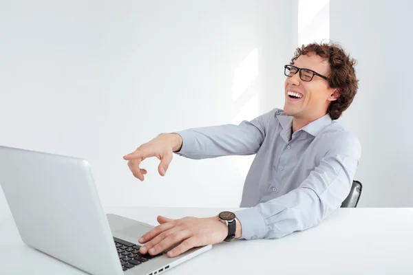 Laughing businessman using laptop computer