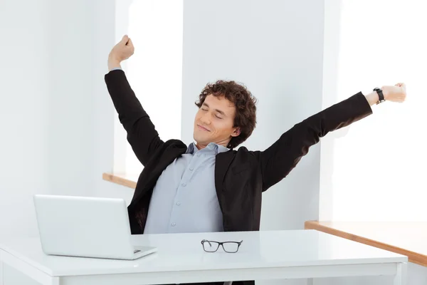 Businessman stretching hands at his workplace