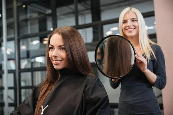 Hairstylist making women's haircut to an attractive woman