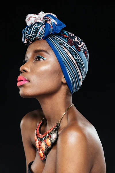 Side view of young african woman on black background