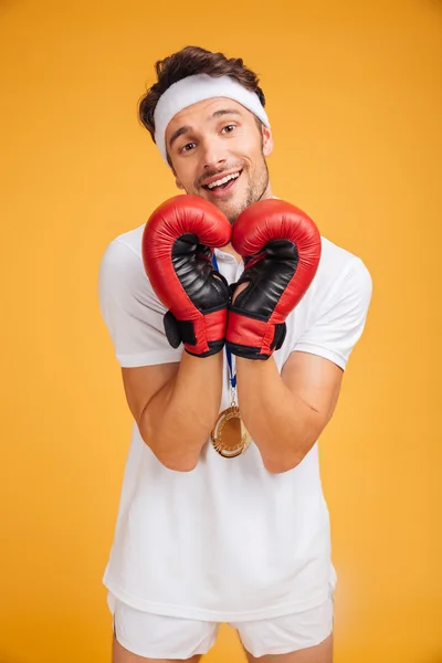Happy man boxer in red gloves making heart by hands