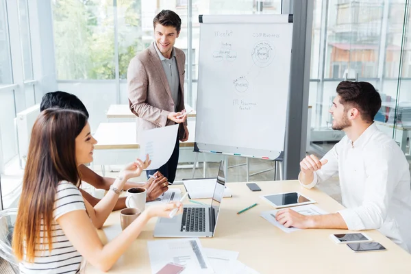 Happy businessman making presentation for business people in office