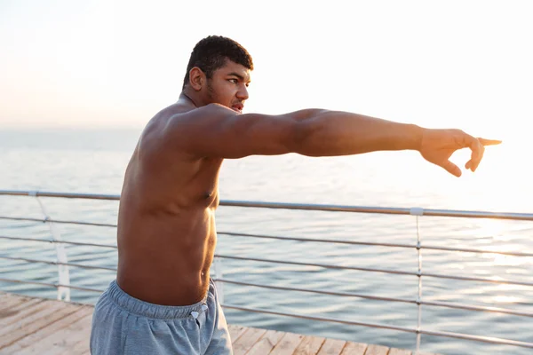 Shirtless african man athlete working out and pointing away