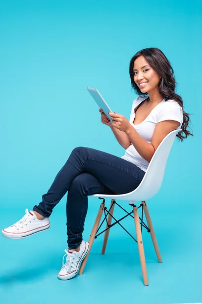 Woman using tablet pc computer while sitting on the chair