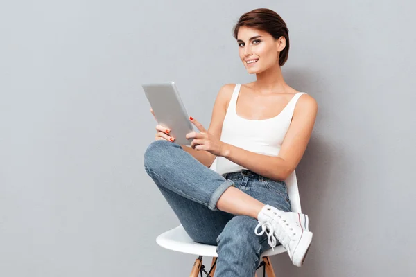Smiling young woman holding tablet pc computer isolated