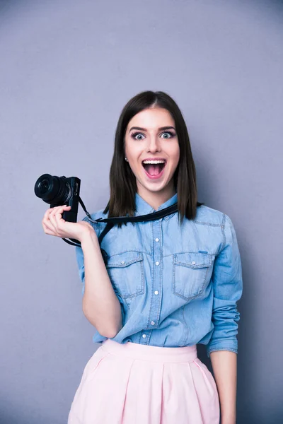 Surprised young cute woman holding camera