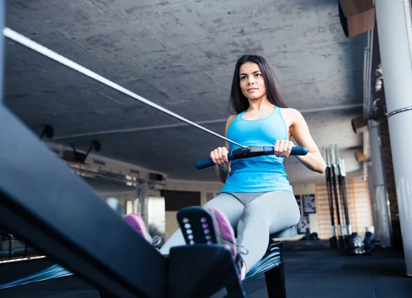 Woman working out on training simulator at gym