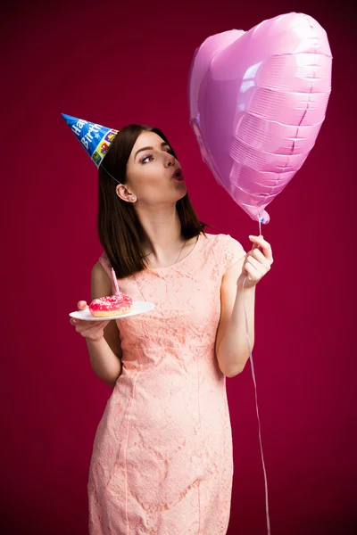 Woman holding donut with candle