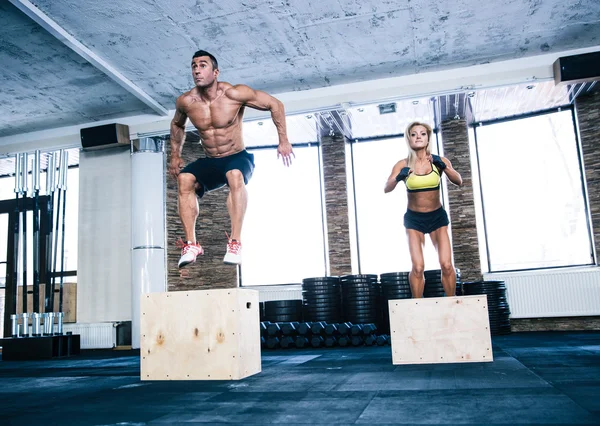 Group of man and woman jumping on fit box