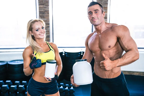 Man and woman holding container with sports nutrition