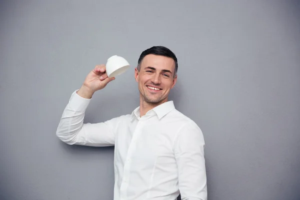 Cheerful businessman holding white cup