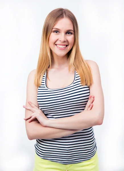 Happy young woman standing with arms folded