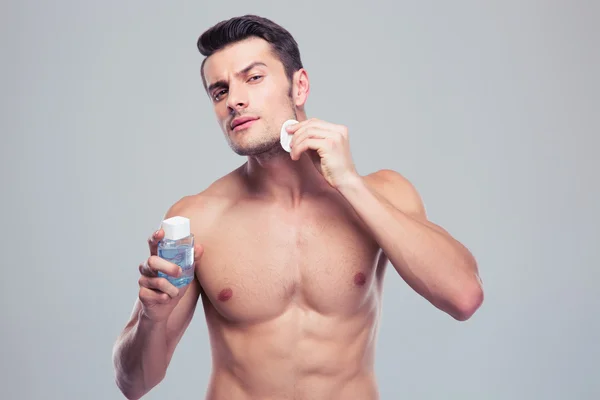 Man applying lotion after shave on face