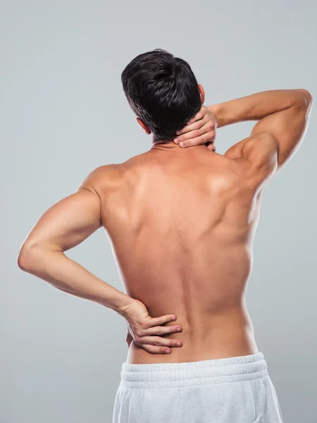 Fitness man standing with back pain
