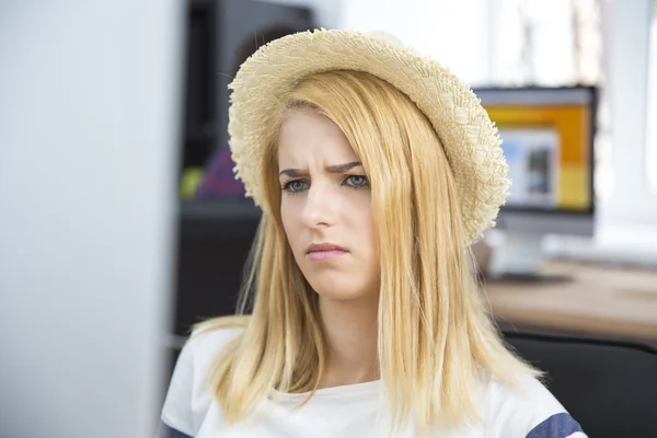 Unhappy woman sitting in office