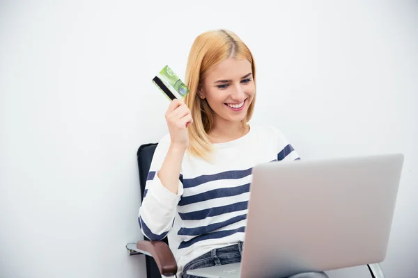 Woman holding laptop and bank card