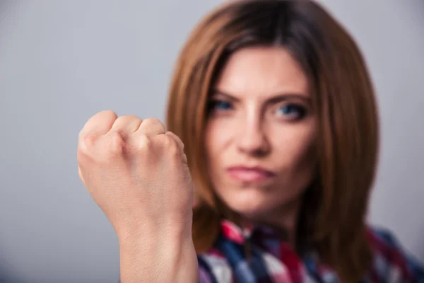 Angry young woman showing fist