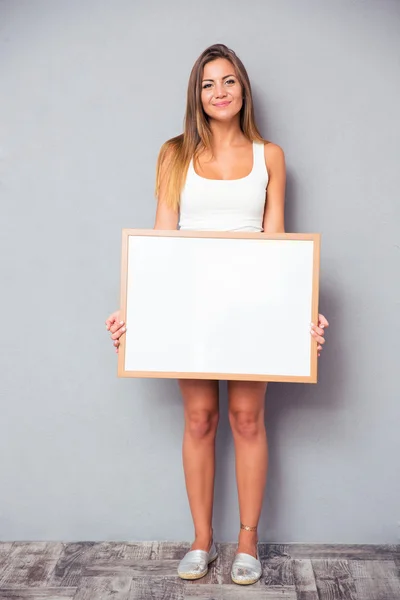 Pretty young girl holding blank board