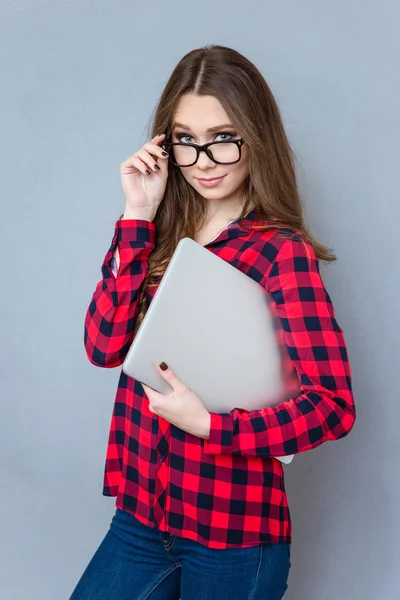 Pretty young woman looking over her glasses